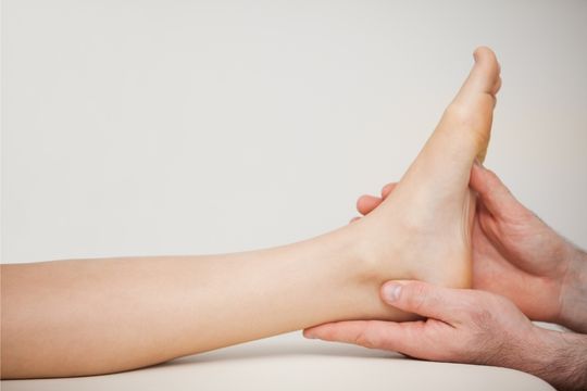chiropractor massaging foot of a patien