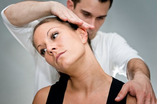 neck specialist stretching a womans neck